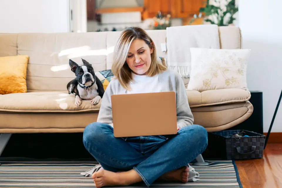 Young woman working from home with a boston terrier dog. Fre